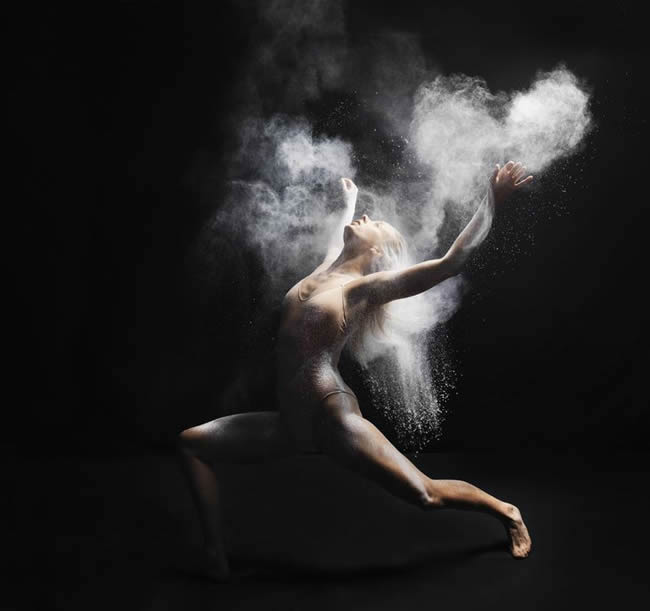 Young dancer performing with white powder