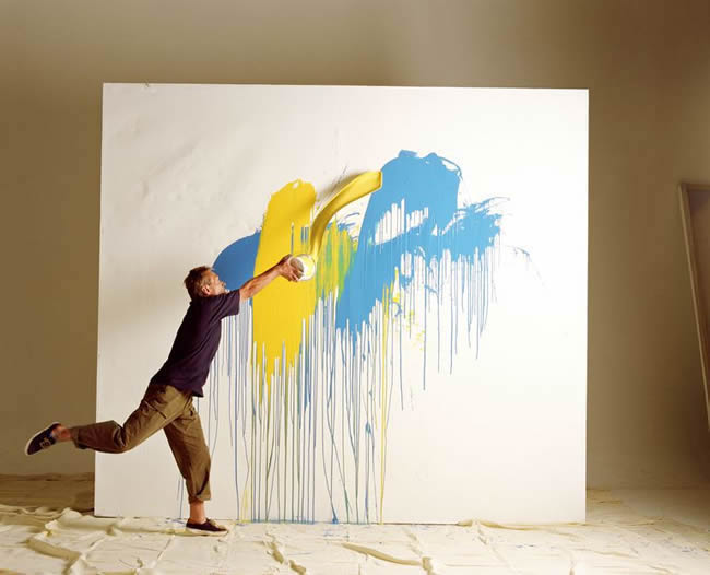 Artist throwing paint at canvas