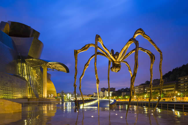 Huge spider sculpture by Louise Bourgeois illuminated at night