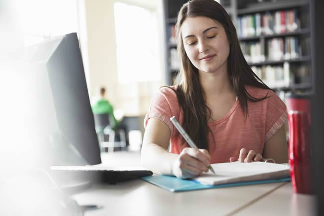 student writing on paper