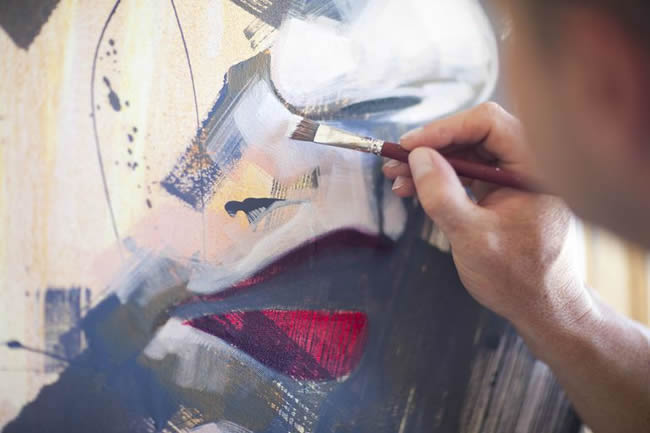Close up of mature male artist working on canvas