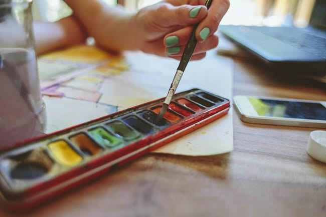 An artist painting with watercolors