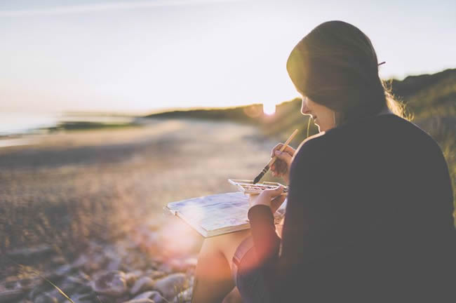 Woman painting on beach