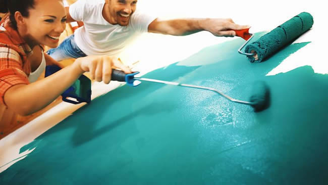 People painting a wall bright turquoise
