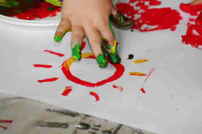Cropped Hand Of Child Painting On Paper