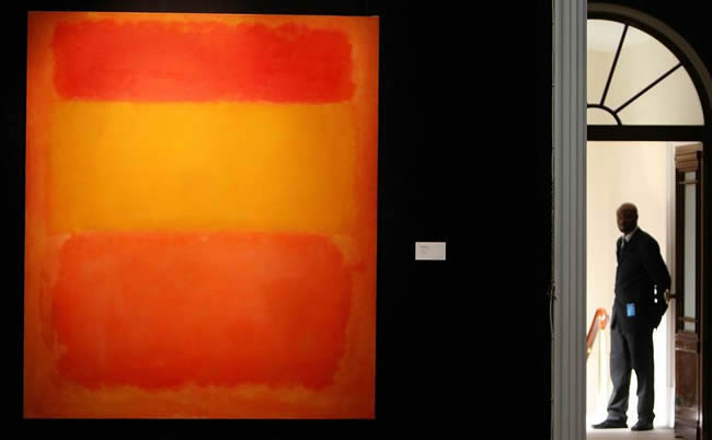 Abstract painting in shades of orange, red, and yellow on display