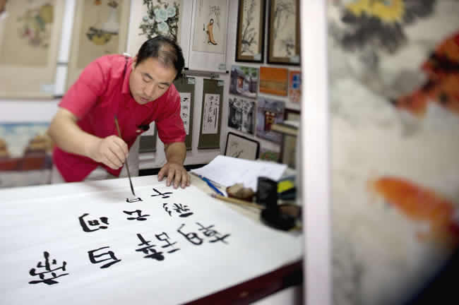 Artist painting outside the Forbidden City, Beijing, China