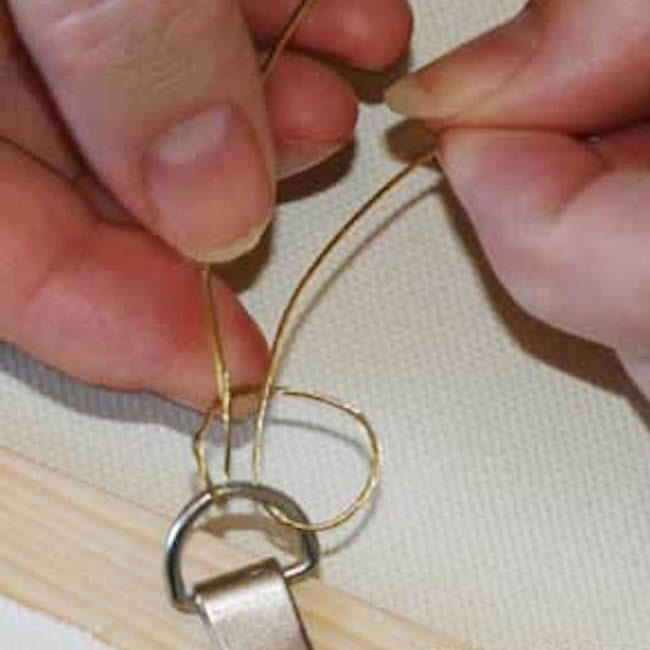 Tying a knot on back of a picture with hanging wire