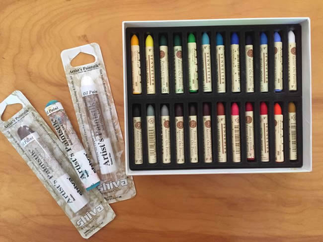 Box of oil pastels and several oil paintsticks