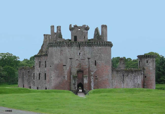 Caerlaverock Castle in Dumfriesshire, Scotland under a blue sky.