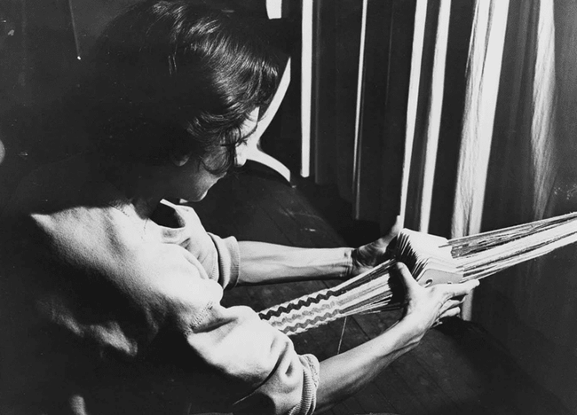 Photograph of Anni Albers card weaving at Black Mountain College.