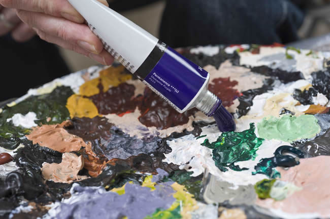 Artist squeezing acrylic Paint