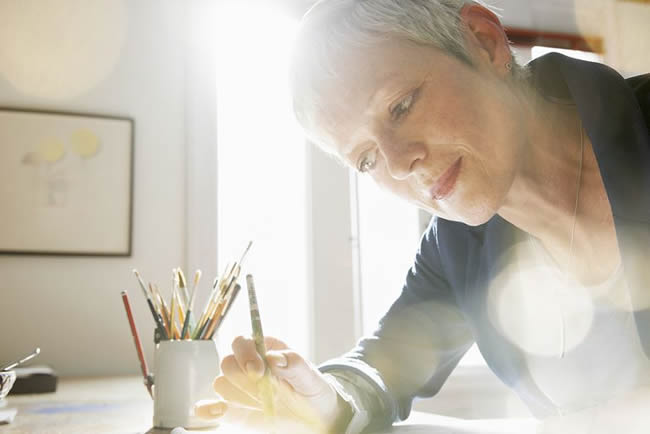 mature woman painting in studio