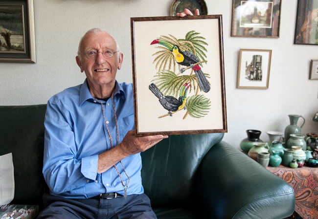 Senior man proudly showing his embroidered artwork
