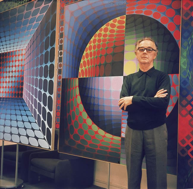 Hungarian born French artist Victor Vasarely (1908 - 1997) poses in front of one of his Op Art paintings