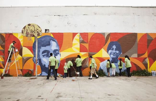 Volunteers painting a wall mural