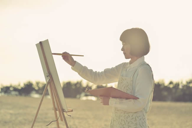 Woman drawing the oil painting on the beach